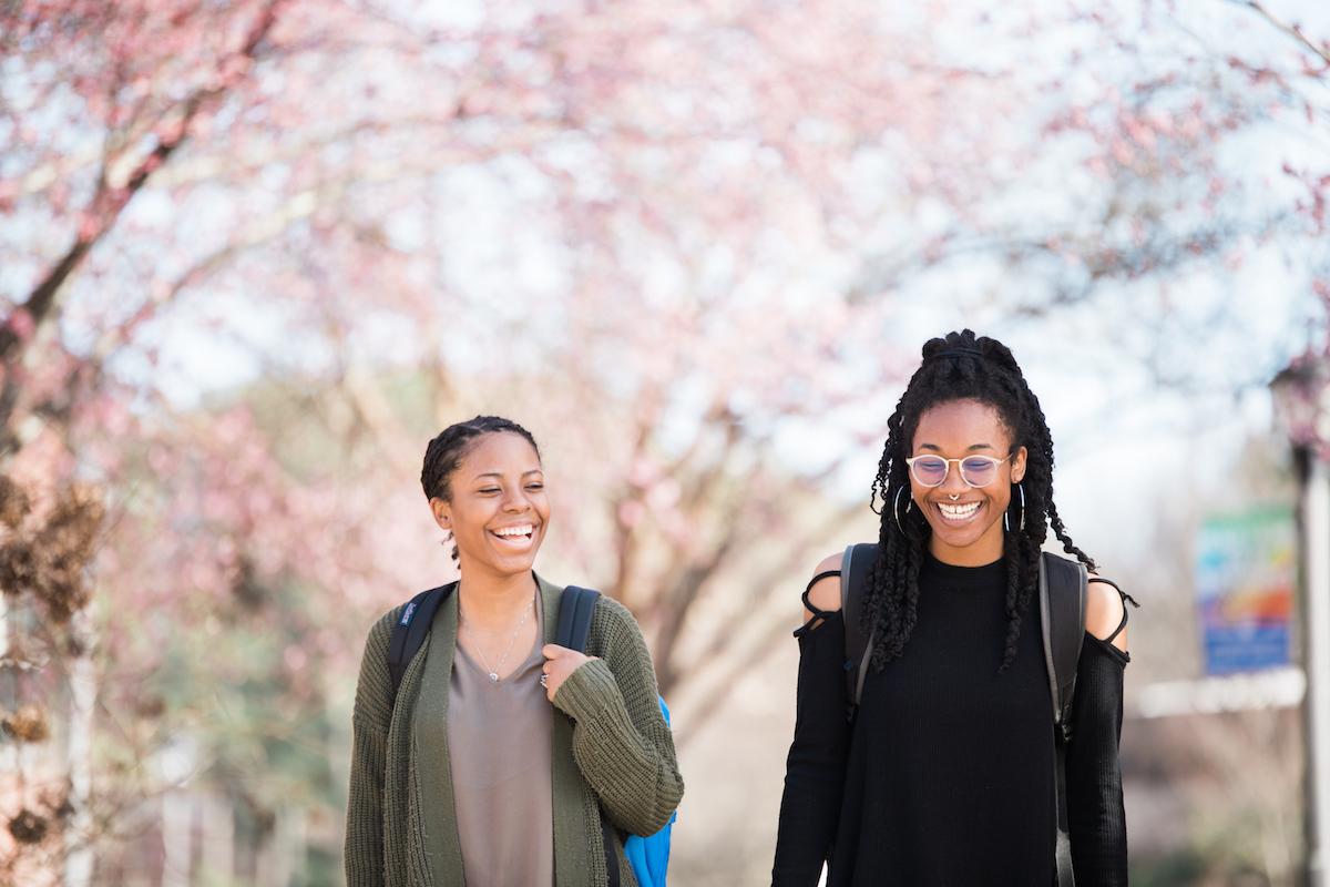 Students smiling outside walking to class.